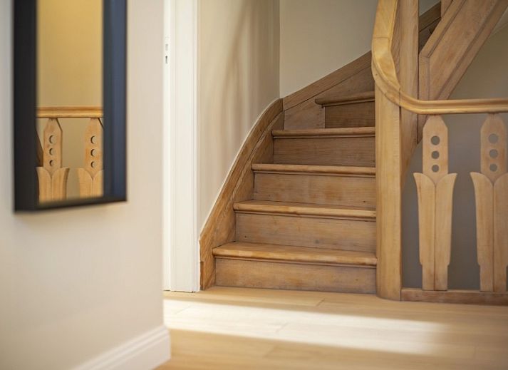 Gemuetlicher Eingang zum Maison Emile, Ferienhaus in De Panne, mit Holztreppe und Willkommensdekoration.