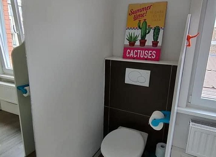 Essecke in La Casita, Ferienhaus De Panne, mit stilvollem Holztisch und viel Tageslicht.