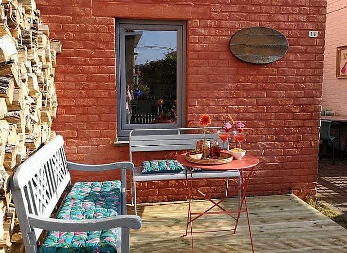 Essecke in La Casita, Ferienhaus De Panne, mit stilvollem Holztisch und viel Tageslicht.