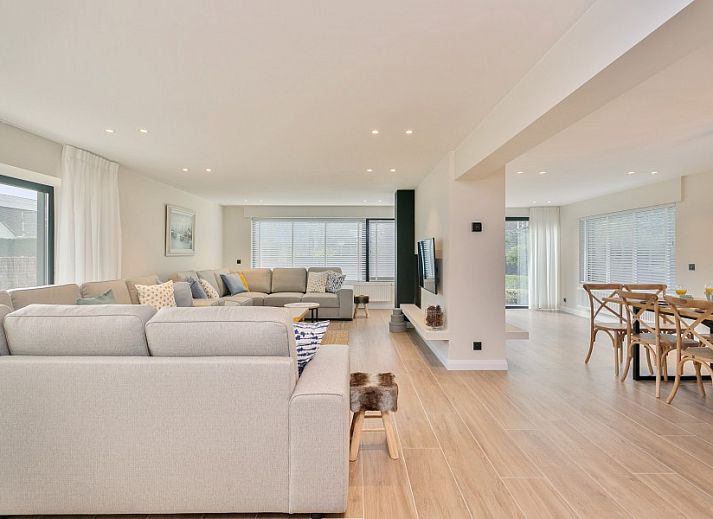 Eetkamer van Villa Miro, vakantiehuis in Sint-Idesbald, met lichte inrichting en houten tafel.