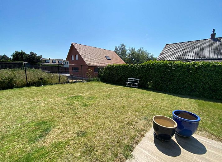 Gemuetliches Wohnzimmer des Ferienhauses Petunias Deluxe in Sint-Idesbald, Westflandern, mit Kamin und bequemer Sitzecke.