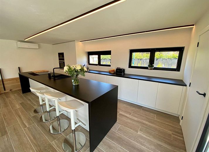 Gemuetliches Wohnzimmer des Ferienhauses Petunias Deluxe in Sint-Idesbald, Westflandern, mit Kamin und bequemer Sitzecke.