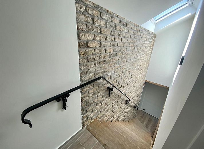 Gemuetliches Wohnzimmer des Ferienhauses Petunias Deluxe in Sint-Idesbald, Westflandern, mit Kamin und bequemer Sitzecke.