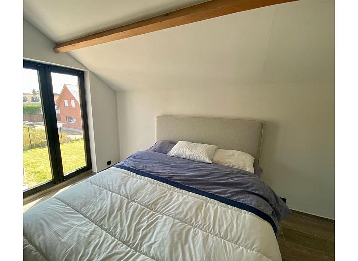 Luxurioeses Schlafzimmer im Ferienhaus Petunias Deluxe, Sint-Idesbald, Westflandern, mit moderner Einrichtung und Gartenblick.