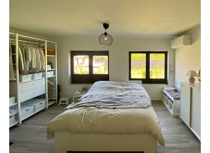 Luxurioeses Schlafzimmer im Ferienhaus Petunias Deluxe, Sint-Idesbald, Westflandern, mit moderner Einrichtung und Gartenblick.