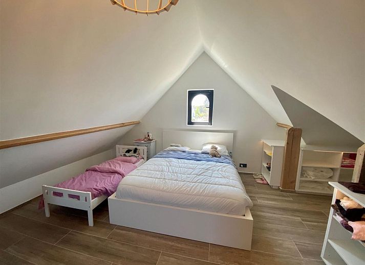 Luxurioeses Schlafzimmer im Ferienhaus Petunias Deluxe, Sint-Idesbald, Westflandern, mit moderner Einrichtung und Gartenblick.