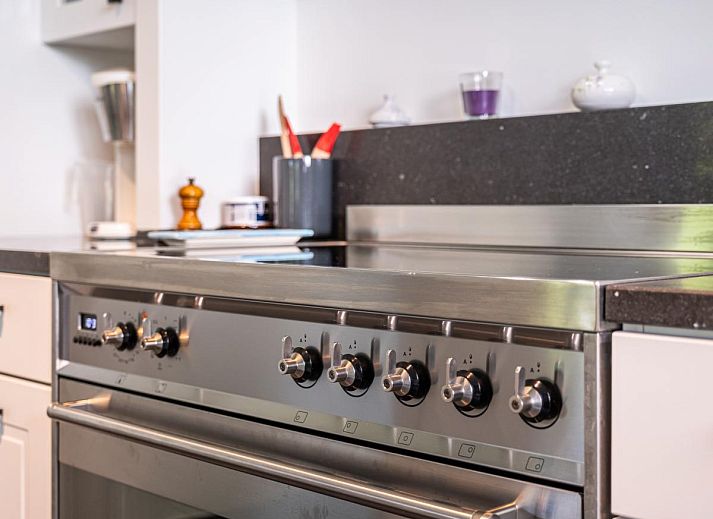 Moderne keuken in vakantiehuis La Matinee, Sint-Idesbald, West-Vlaanderen met ruime kookeiland en tuinzicht.