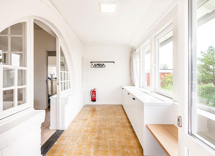 Stijlvolle woonkamer van La Classe vakantiehuis in Sint-Idesbald, West-Vlaanderen, Belgie met comfortabele zitruimte en veel natuurlijk licht.