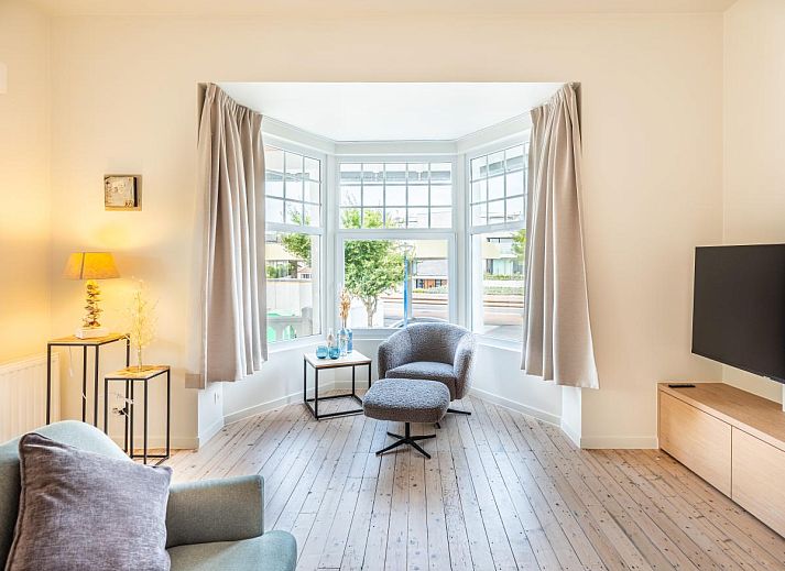 Stijlvolle woonkamer van La Classe vakantiehuis in Sint-Idesbald, West-Vlaanderen, Belgie met comfortabele zitruimte en veel natuurlijk licht.