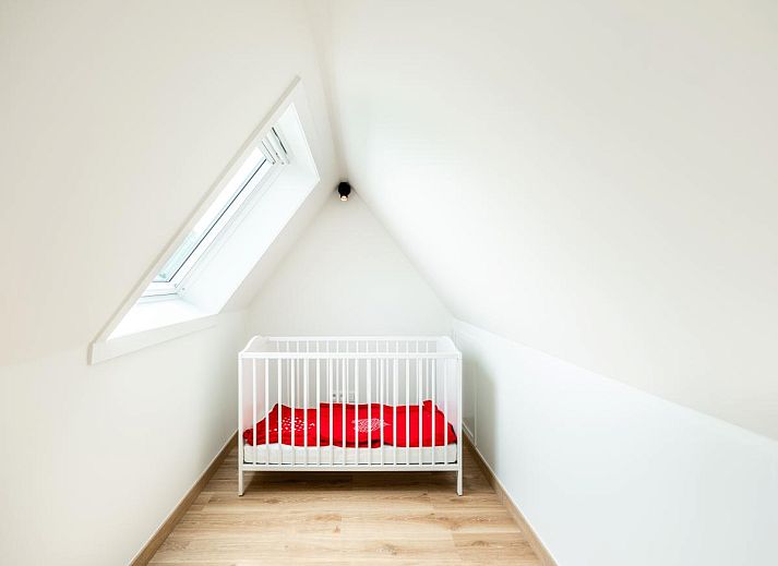 Sfeervolle slaapkamer in vakantiehuis La Classe, Sint-Idesbald, West-Vlaanderen, met lichte inrichting en uitzicht op de groene omgeving.