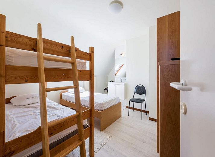 Gezellige woonkamer van vakantiehuis Aubepine troisieme in Sint-Idesbald, West-Vlaanderen, met comfortabele zithoek en veel natuurlijk licht.
