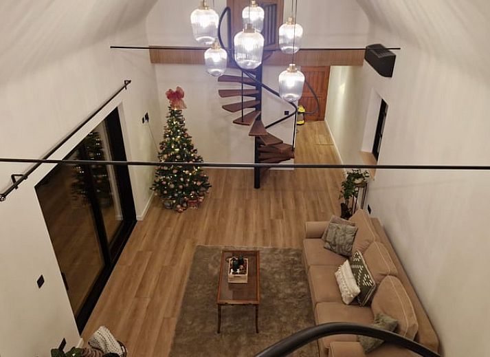 Gemuetliches Wohnzimmer im Ferienhaus in Ruiselede, einem Ferienhaus in Westflandern, komplett mit Weihnachtsbaum und komfortabler Sitzecke.