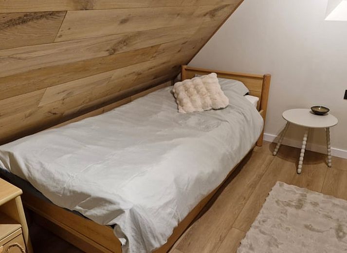 Gemuetliches Wohnzimmer im Ferienhaus in Ruiselede, einem Ferienhaus in Westflandern, komplett mit Weihnachtsbaum und komfortabler Sitzecke.