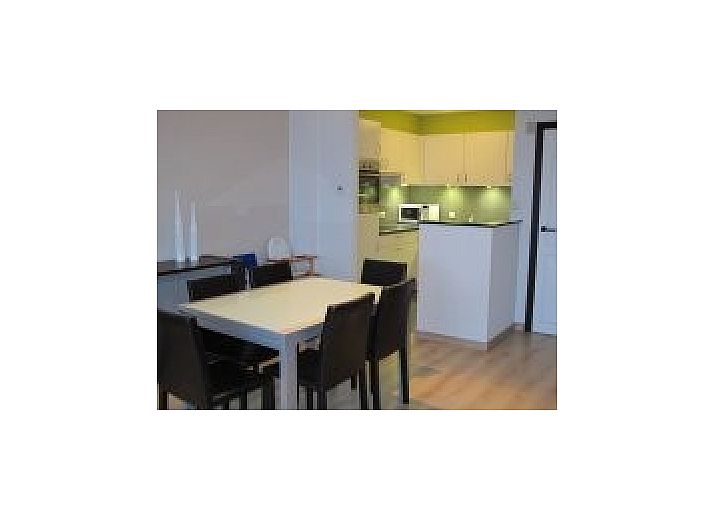 Gezellige woonkamer in Appartemen-Heist, Knokke-Heist, met moderne inrichting en open keuken in West-Vlaanderen, Belgie.