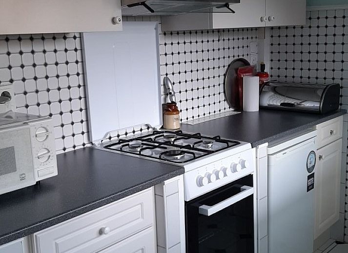 Gezellige woonkamer in FLORIVAN 1, vakantiehuis in Oostende, Belgische kust, met comfortabele zithoek en eethoek voor vier personen.