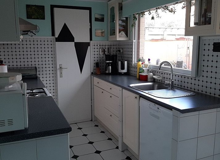 Gezellige woonkamer in FLORIVAN 1, vakantiehuis in Oostende, Belgische kust, met comfortabele zithoek en eethoek voor vier personen.