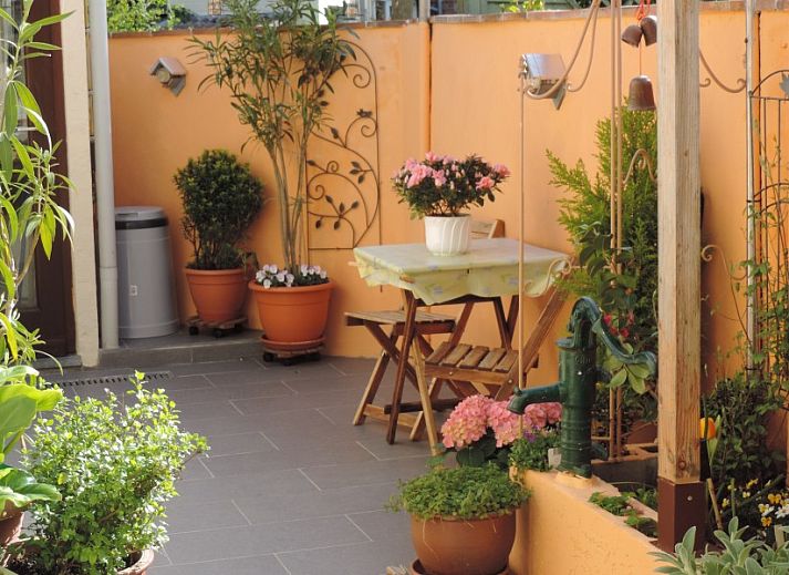 Buitenkant van FLORIVAN 1, vakantiehuis in Oostende, Belgische kust, met charmant balkon en kleurrijke bloemen.