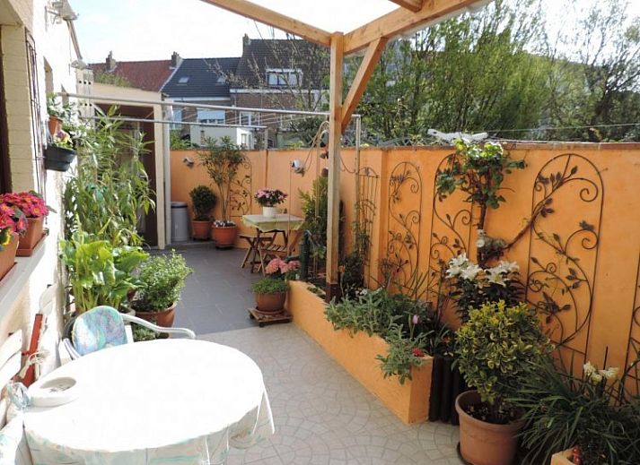 Buitenkant van FLORIVAN 1, vakantiehuis in Oostende, Belgische kust, met charmant balkon en kleurrijke bloemen.