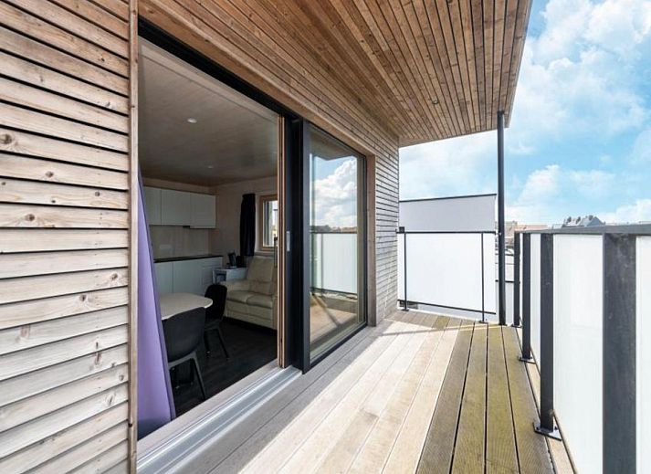 Gemuetlicher Innenbereich der Kruiers Eco Lodge in Middelkerke, Westflandern, mit Blick auf die Terrasse und den gemuetlichen Sitzbereich.