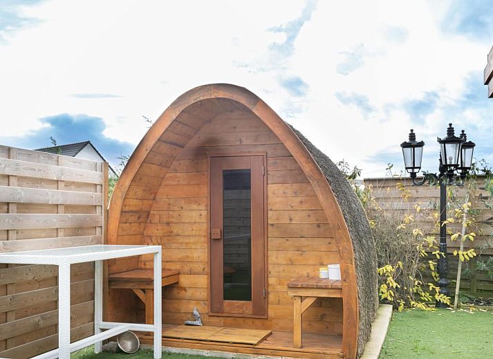 Vorderansicht des Ferienhauses De Golfbreker in Middelkerke, umgeben von einem Zaun und einer Steinauffahrt in Westflandern.