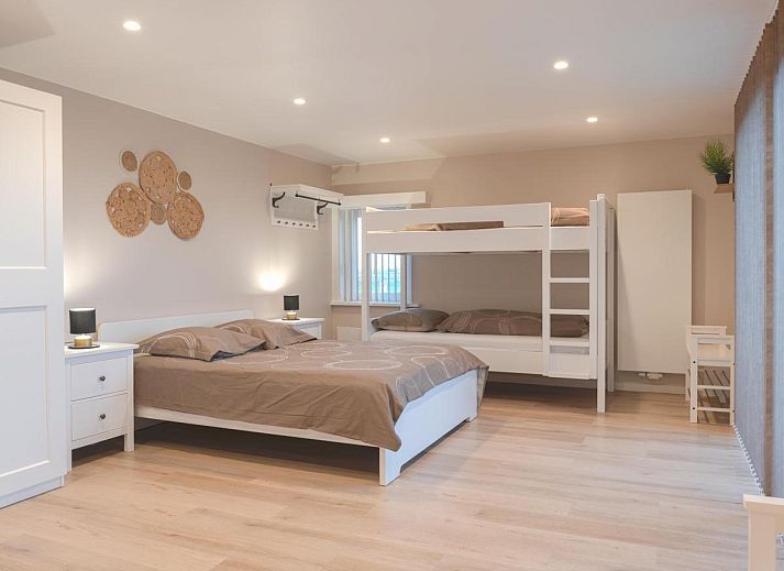 Geraeumige Terrasse von De Golfbreker in Middelkerke mit Holztisch und Stuehlen, ideal fuer Mahlzeiten im Freien in Westflandern.