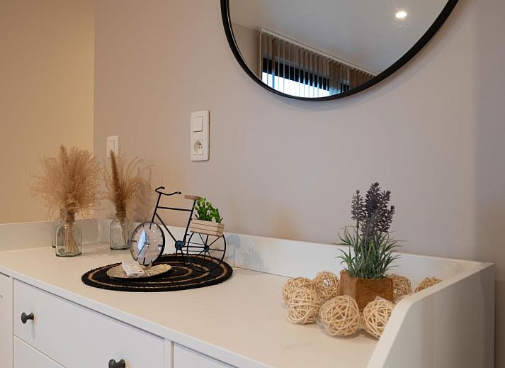 Geraeumige Terrasse von De Golfbreker in Middelkerke mit Holztisch und Stuehlen, ideal fuer Mahlzeiten im Freien in Westflandern.