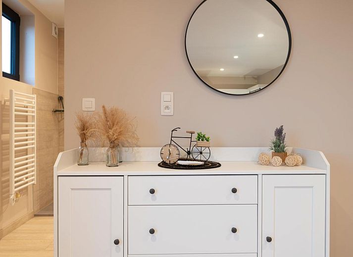 Geraeumige Terrasse von De Golfbreker in Middelkerke mit Holztisch und Stuehlen, ideal fuer Mahlzeiten im Freien in Westflandern.