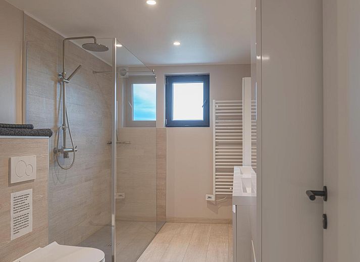 Aussenbereich von De Golfbreker in Middelkerke mit grossem Esstisch und Gartenblick in Westflandern.