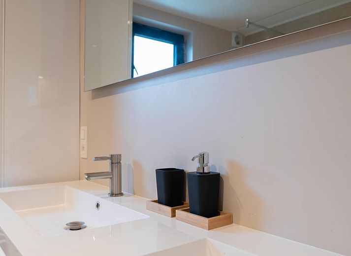 Aussenbereich von De Golfbreker in Middelkerke mit grossem Esstisch und Gartenblick in Westflandern.