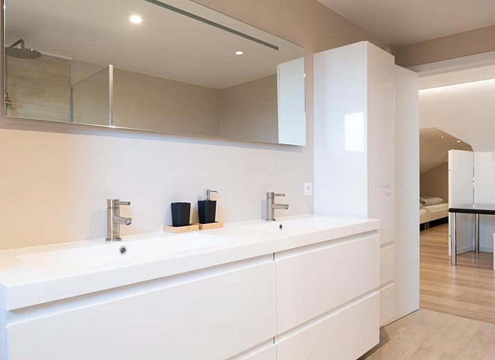 Aussenbereich von De Golfbreker in Middelkerke mit grossem Esstisch und Gartenblick in Westflandern.