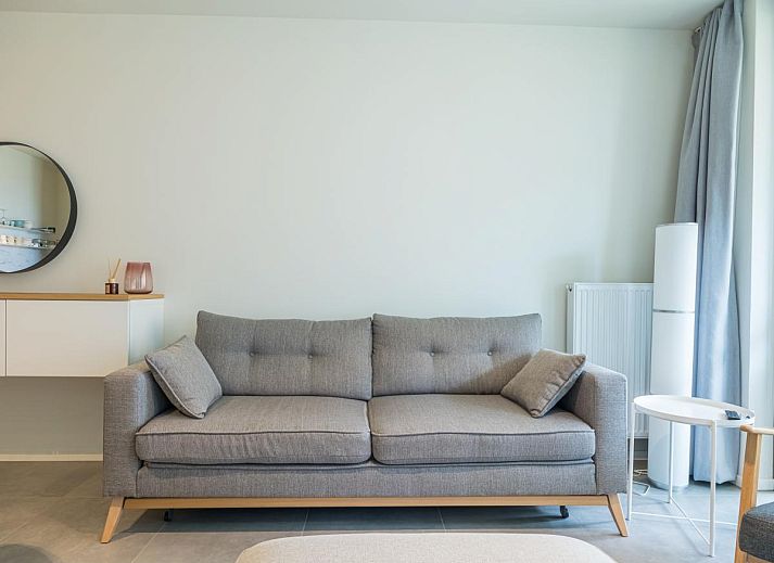 Geraeumiges Wohnzimmer des Ferienhauses Ancilla - 0105 in Middelkerke, Westflandern, mit moderner Einrichtung und offener Kueche.