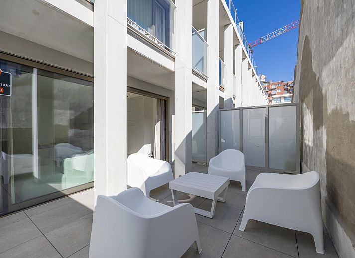 Helles Wohnzimmer des Ferienhauses Omnia 7 - 0103 + Park in Middelkerke, Westflandern, mit moderner Einrichtung und Blick auf die Terrasse.