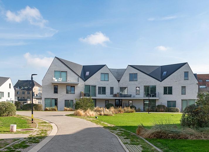 Veranda van West Bay vakantiehuis in Westende, West-Vlaanderen, met comfortabele zitplaatsen en groene omgeving.