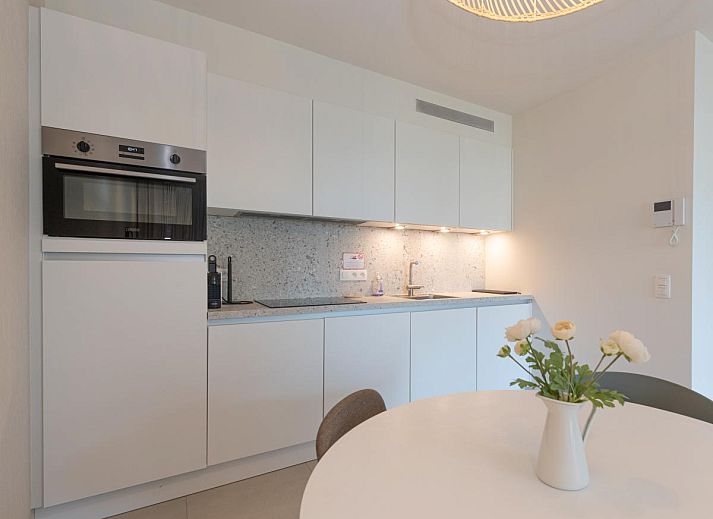 Veranda van West Bay vakantiehuis in Westende, West-Vlaanderen, met comfortabele zitplaatsen en groene omgeving.