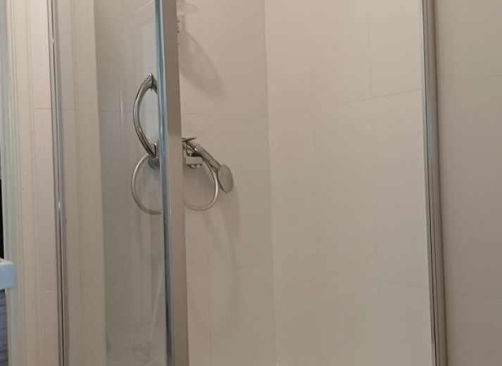 Lichte eetkamer met haard in Vakantiehuis Alegria, Westende, West-Vlaanderen.