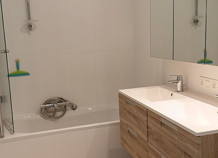Lichte eetkamer met haard in Vakantiehuis Alegria, Westende, West-Vlaanderen.