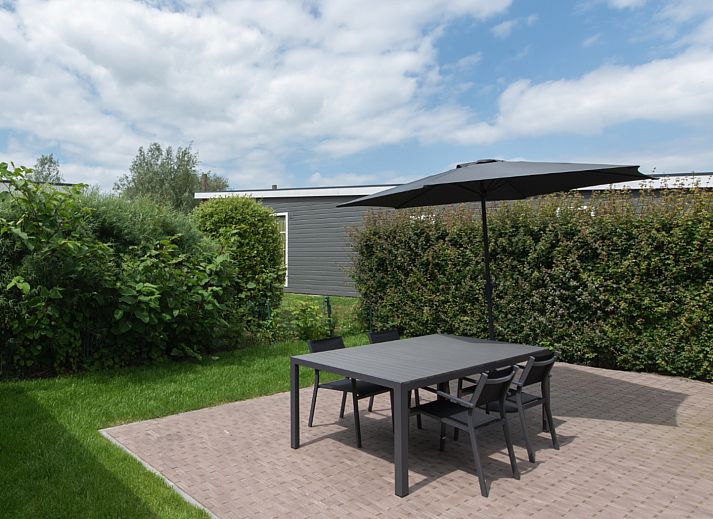 Stilvolles Wohnzimmer in Access Lodge, einem Ferienhaus in Westende, Westflandern, mit bequemer Sitzecke und Gartenblick.