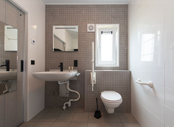 Gemuetliches Wohnzimmer der Access Lodge, Ferienhaus in Westende, Westflandern, mit gemuetlicher Einrichtung und verspieltem Hund.