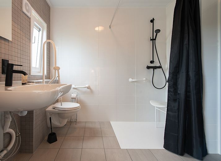 Gemuetliches Wohnzimmer der Access Lodge, Ferienhaus in Westende, Westflandern, mit gemuetlicher Einrichtung und verspieltem Hund.