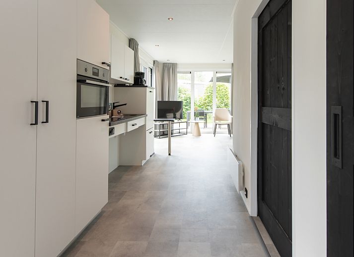 Gemuetliches Wohnzimmer der Access Lodge, Ferienhaus in Westende, Westflandern, mit gemuetlicher Einrichtung und verspieltem Hund.