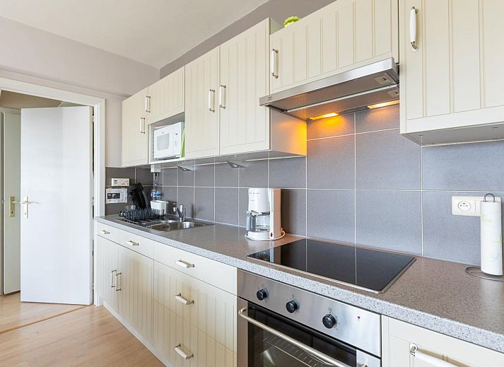 Lichte woonkamer van vakantiehuis Con Amore - 0403 in Westende, Belgie, met moderne open keuken en comfortabele zithoek.