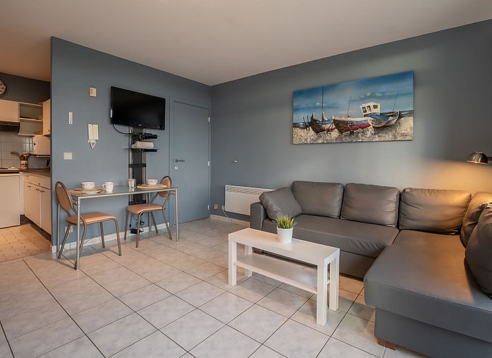 Gezellige binnenruimte van Appartement Studio 502 in Bredene, West-Vlaanderen met uitzicht op de stad en comfortabel ingerichte slaap- en zithoek.