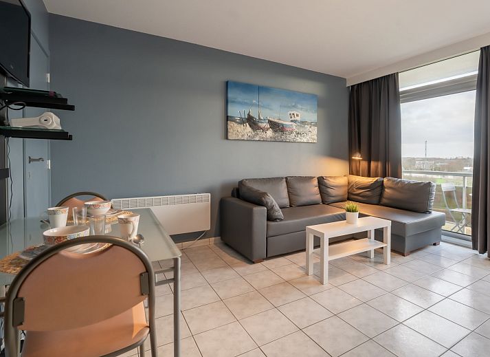 Gezellige binnenruimte van Appartement Studio 502 in Bredene, West-Vlaanderen met comfortabel bed en uitzicht op de stad.