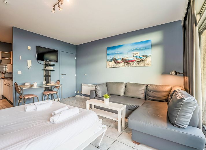 Gezellige binnenruimte van Appartement Studio 502 in Bredene, West-Vlaanderen met comfortabel bed en uitzicht op de stad.