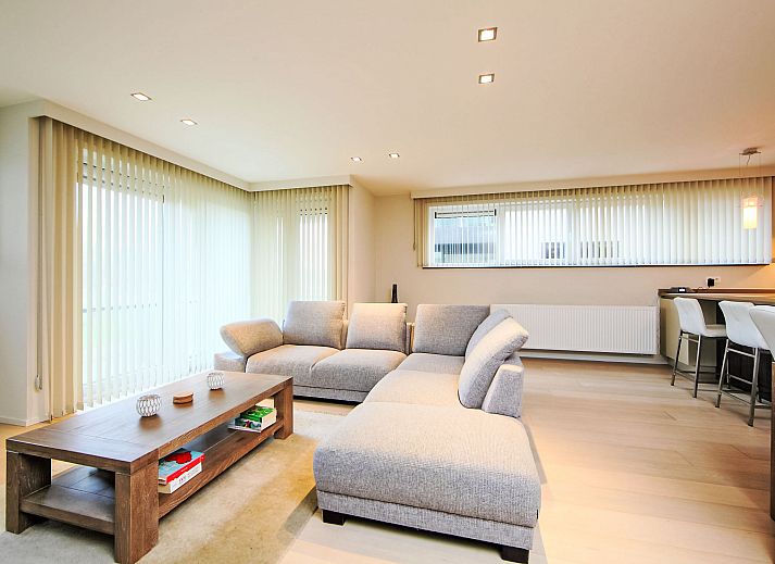 Stijlvolle woonkamer van Appartement Cocoon in Bredene, West-Vlaanderen, Belgie met moderne inrichting en comfortabele zithoek.