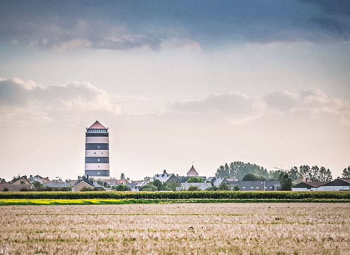 Zonnig terras van Appartement Cocoon in Bredene, West-Vlaanderen, Belgie, met houten tuinmeubilair en uitzicht op de moderne omgeving.
