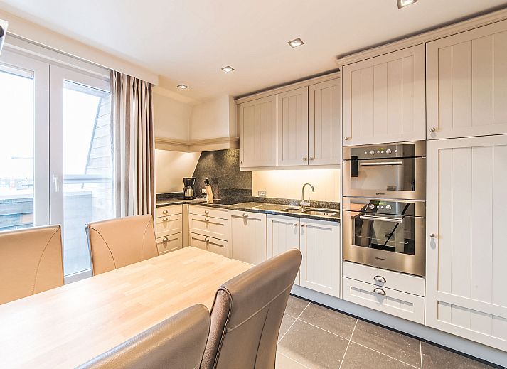 Geraeumiges Wohnzimmer des Apartment Duplex in Bredene, Westflandern, mit einem eleganten Essbereich und einer bequemen Sitzecke.