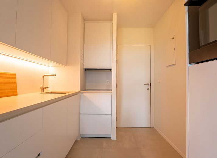 Helles Wohnzimmer der Ferienwohnung Residentie Astrid in Bredene, Westflandern, mit Blick auf den Garten und moderner Moeblierung.