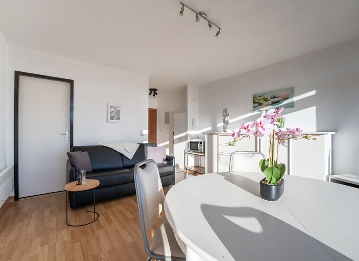 Helles Wohnzimmer der Ferienwohnung Residentie Astrid in Bredene, Westflandern, mit Blick auf den Garten und moderner Moeblierung.
