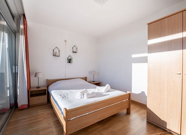 Helles Wohnzimmer der Ferienwohnung Residentie Astrid in Bredene, Westflandern, mit Blick auf den Garten und moderner Moeblierung.